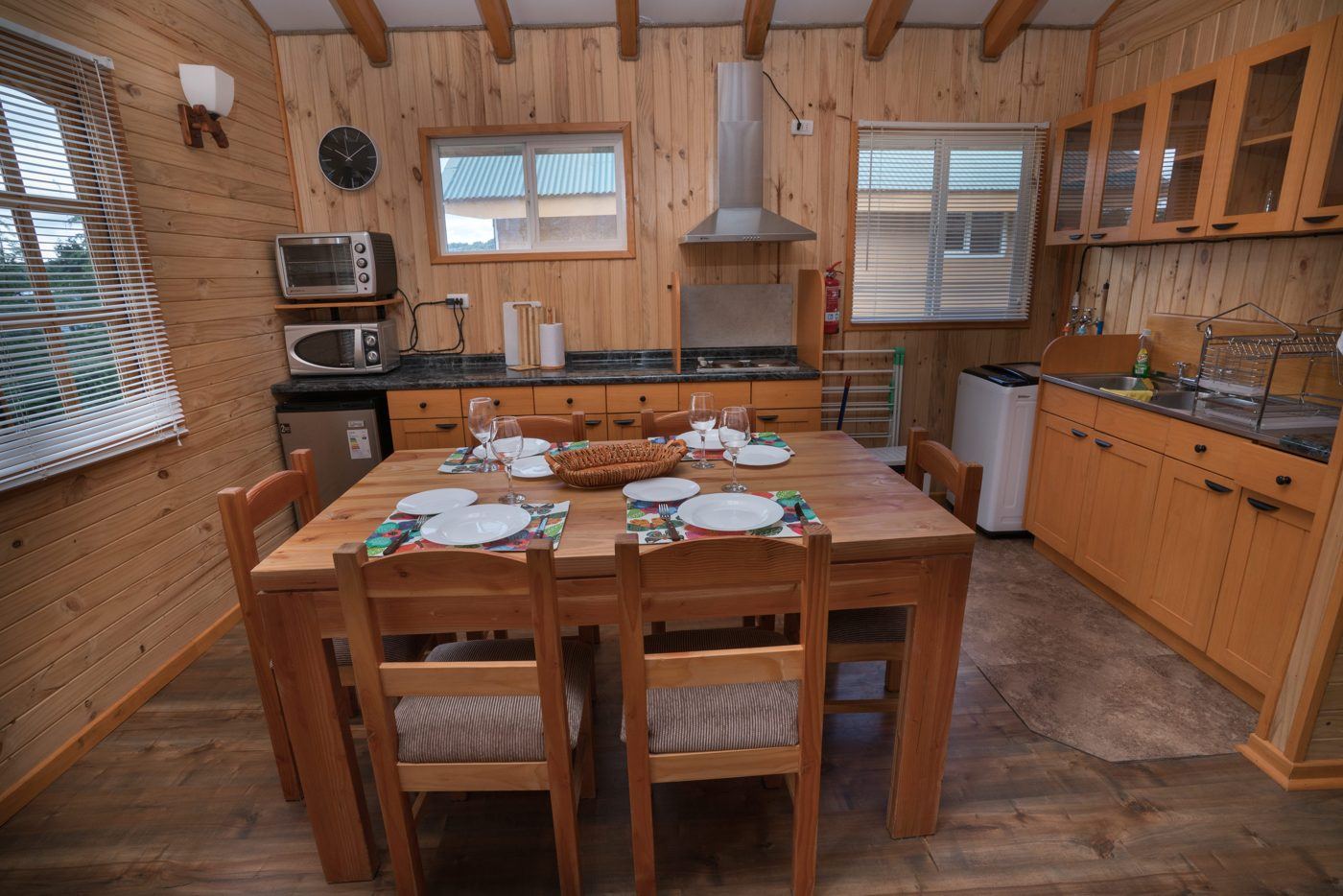 Cozinha e sala de jantar de uma cabana Rilamar, com mesa de madeira posta para seis