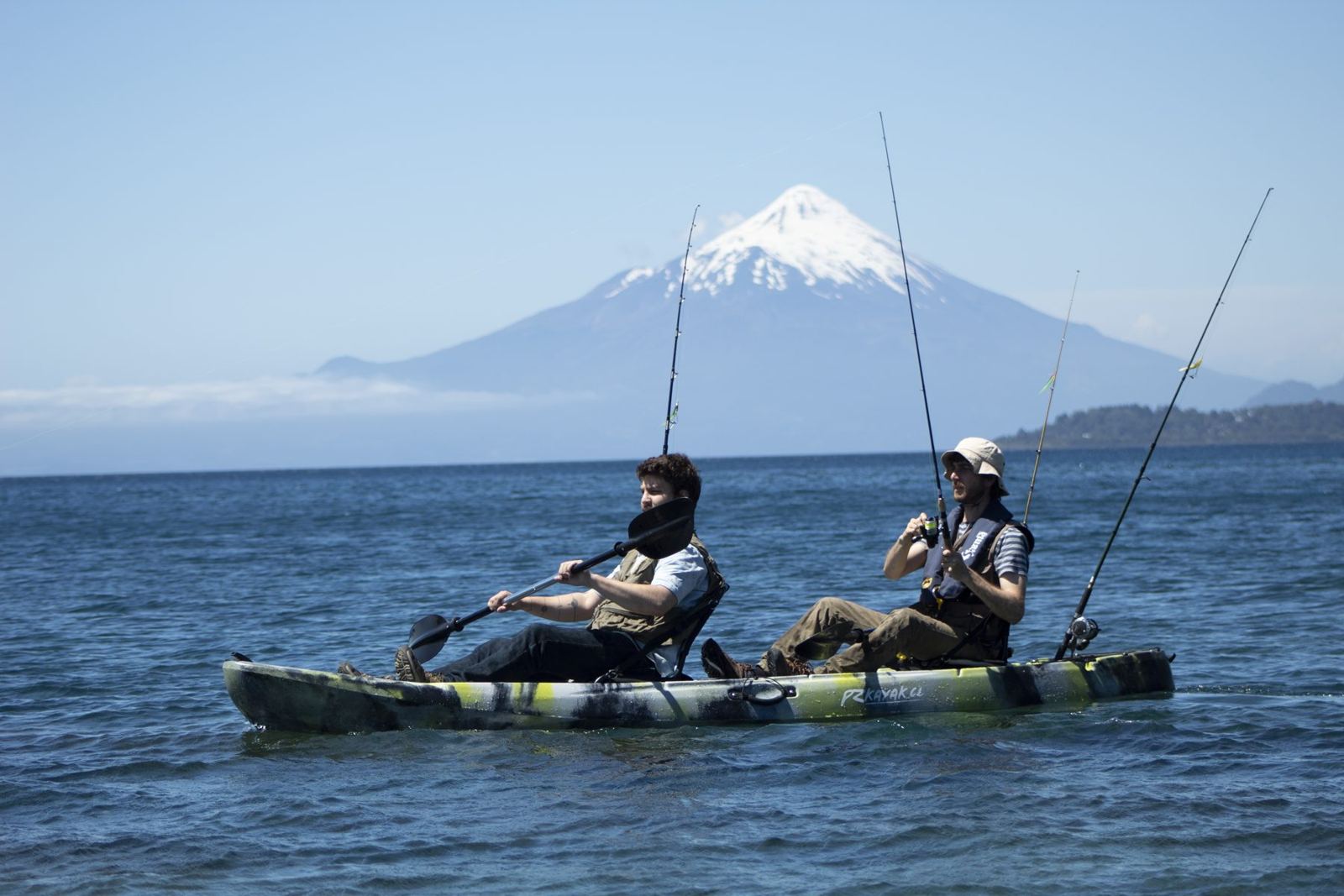 Dois pescadores em um caiaque duplo no Lago Llanquihue, com o vulcão Osorno nevado ao fundo