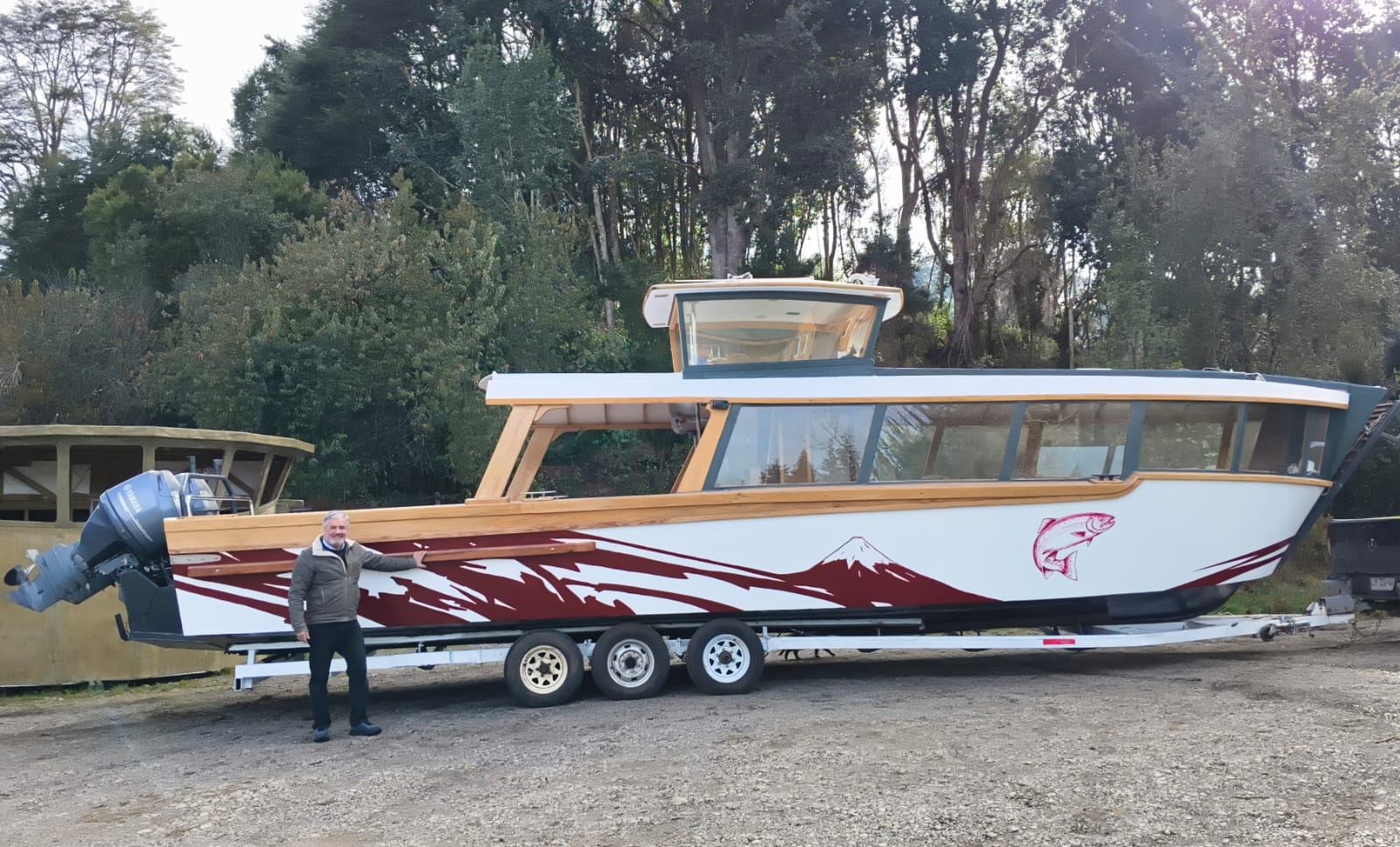 Lancha Lago Llanquihue, de 12 metros, com casco branco, cabine de madeira e desenho do vulcão Osorno e de uma truta
